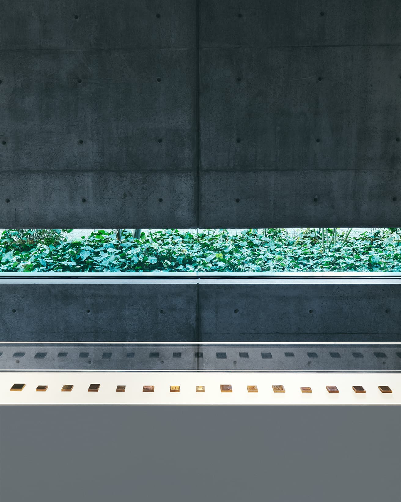 連作《モネについて考える》2014-18年／全65点の展示風景。手のひらに収まるほどの小さなスチールに極細の彫りが刻まれた作品は、見る角度によって劇的に色が変化する。モネが住んだジヴェルニーに見られる積みわらから着想を得たシリーズ。