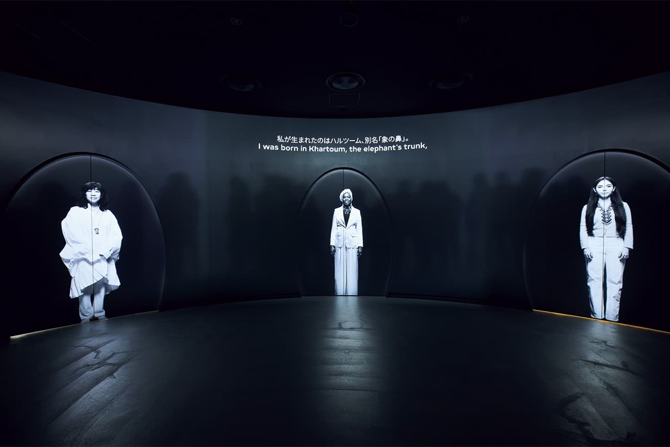 「THREE WOMEN」　来場者はヘッドフォンを装着し、自分のファーストネームを登録すると映像が始まる。3つの扉に現れるのは右からシエ・バスティダ（メキシコ人／環境保護活動家）、エムティハル・マフムード（スーダン系アメリカ人／詩人・アクティビスト）、吉本ばなな（日本人／作家）で3人は各自自己紹介をする。