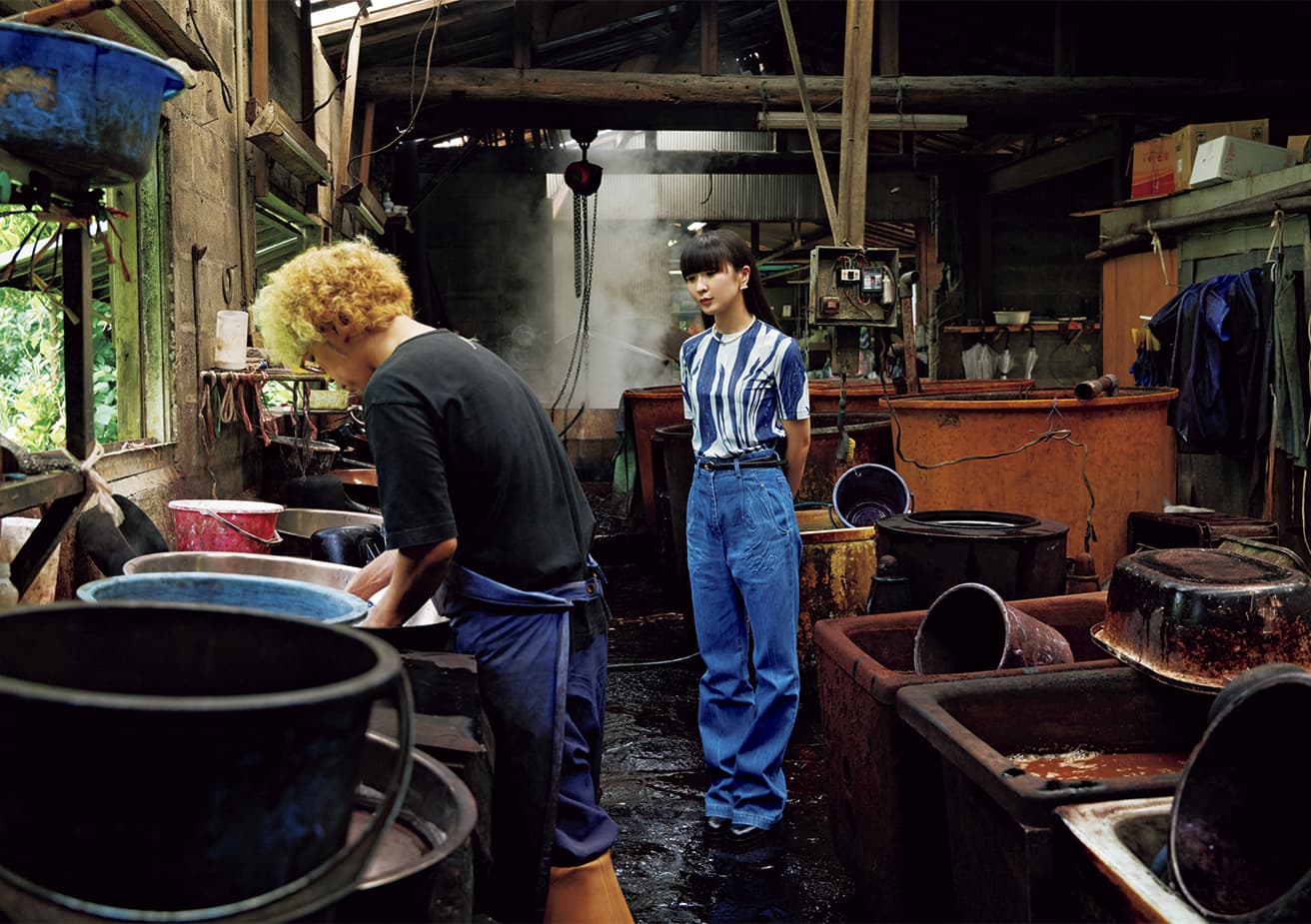With a history of over 1,300 years, dorozome, mud-dyeing, has been employed expressly in the coloring of the fibers used, as well as for the process of kasuri, a hand-dyeing technique, in the making of kimono textile known as Ōshima tsumugi. Here, with Mr. Kanai Yukihito, who has been working to produce a wide range of items using the traditional techniques, our shopkeeper KASHIYUKA chooses furoshiki (wrapping cloths) dyed with doro, or plain mud (left); aidoro, a mix of indigo and mud (center); and indigo (right).