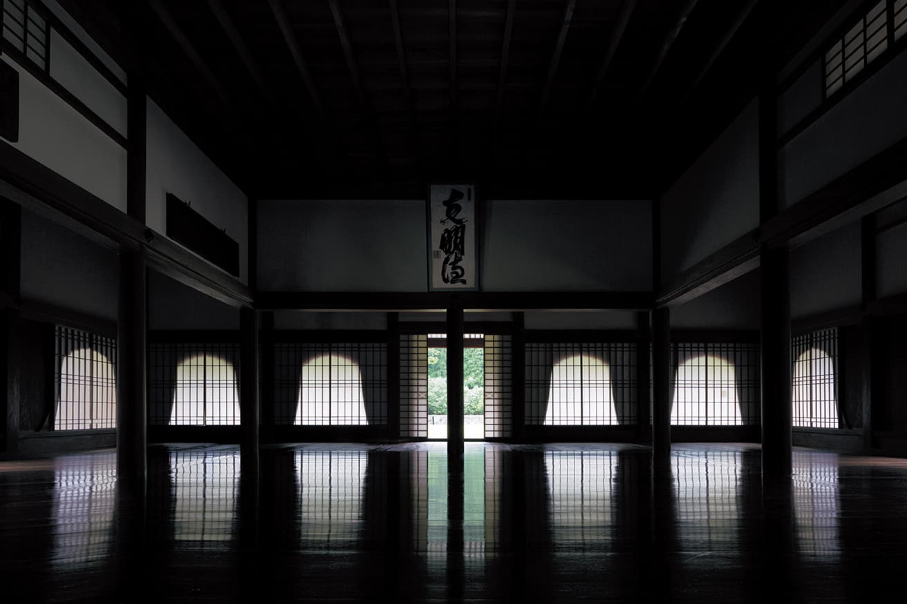 閑谷学校の講堂。中央の空間を囲む10本の円柱は直径25cm以上の欅（欅）の木で作られている。正面にある「克明徳」の書は5代藩主・池田治政によるもの。