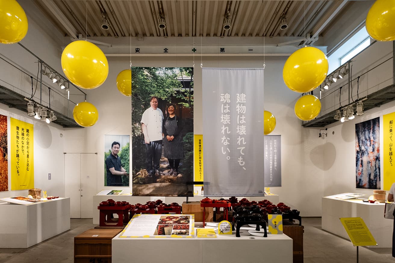 〈金沢21世紀美術館〉のプロジェクト工房がチェックインポイントで、芸術祭の拠点。小倉ヒラク＆発酵デパートメント「みえないものを感じる旅へ〜加賀・能登の発酵文化人類学」の展示。発酵菌をモチーフにした黄色の丸が展示全体の目印だ。