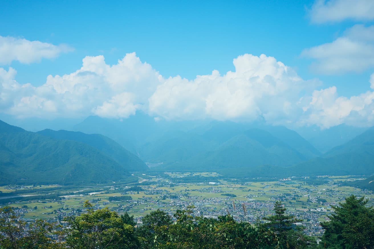 「北アルプス国際芸術祭」が開かれる長野県大町市。空と山に囲まれるようにして家や田が広がる。photo_Takeshi Shinto
