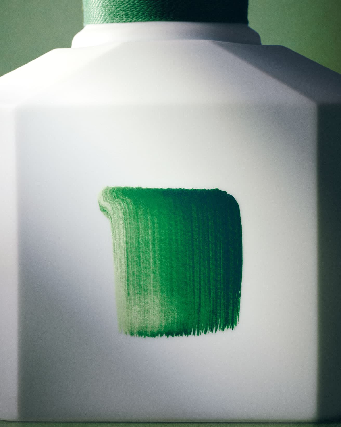 磁器製ボトルに描かれた緑色の筆致は、李禹煥の代表作《Dialogue-対話》に連なる。全神経を集中して描かれたペイントと、描かれなかった余白との関係性をこそ表現したいという哲学的かつ詩的な絵画は、目に見えない香りが示唆するものを象徴するようだ。photo_Masaki Ogawa styling_Tomomi Nagayama