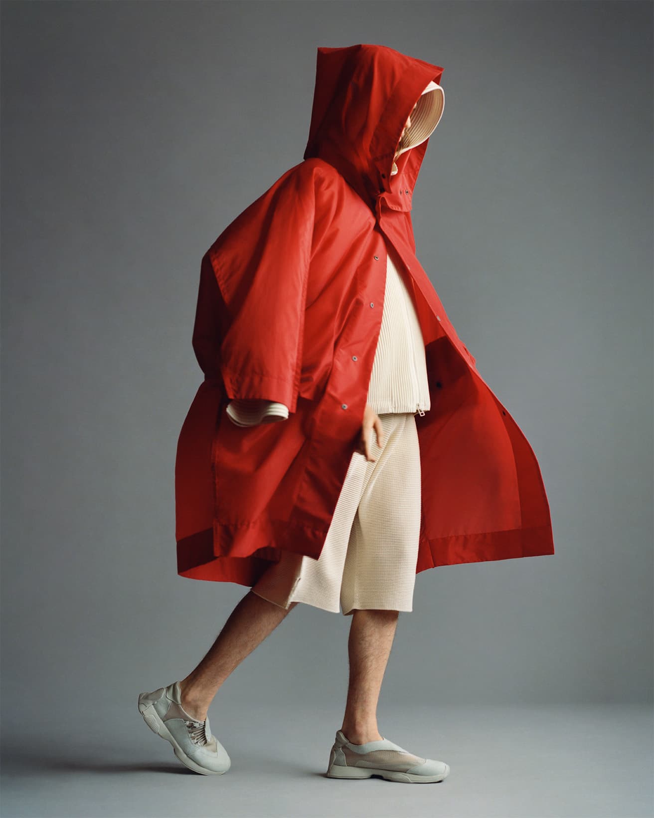 《KITE COAT》。風を受けた凧の膨らみをイメージ。曲線状にダブルステッチを施した継ぎ目など、作り方も細部に至るまで凧。ポケットにも入る。コート93,500円。中に着たジップカーディガン63,800円。