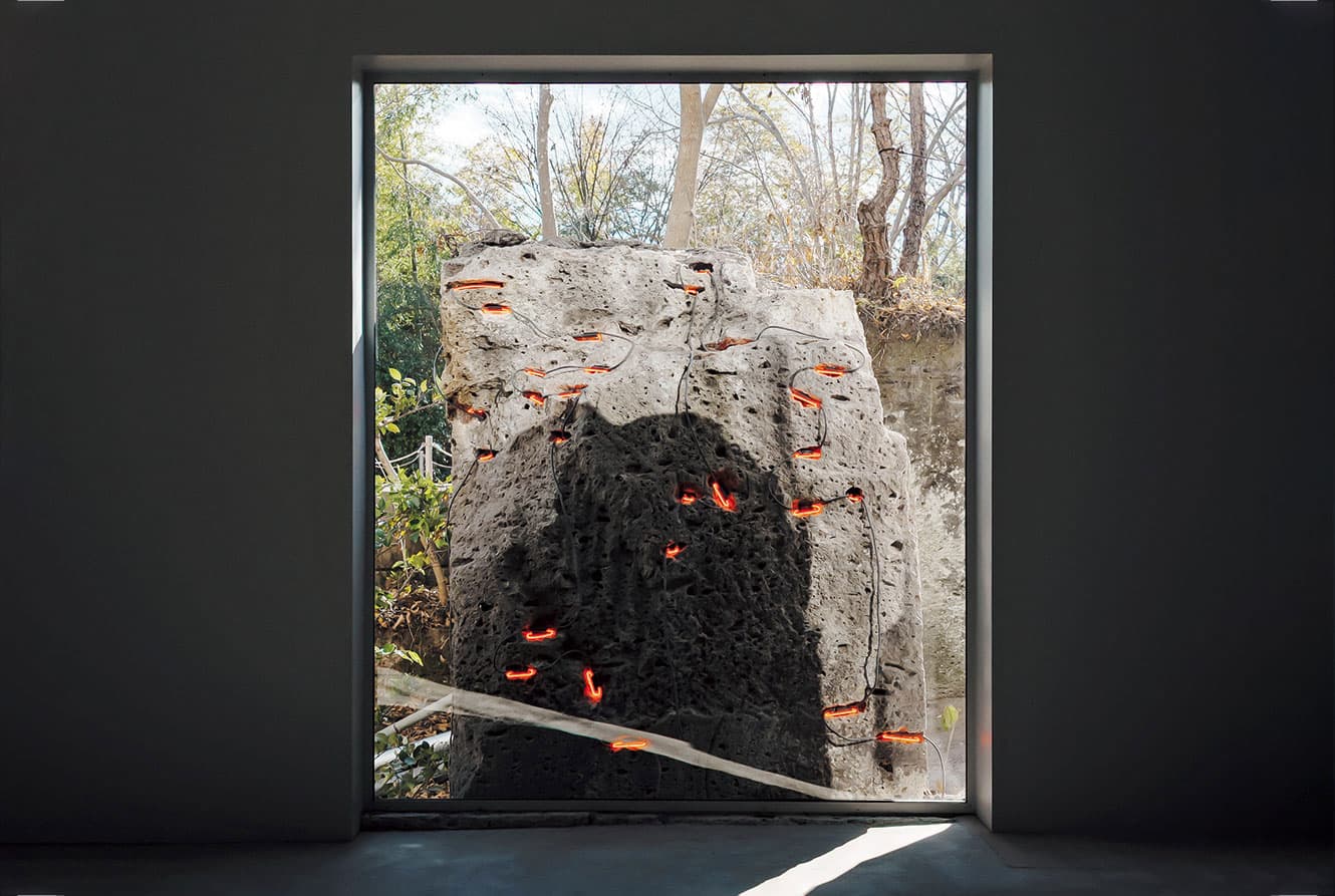 大谷石の “ミソ” にネオンを組み込んだ《Transtone》。石は開業以前からこの場所にあったもの。