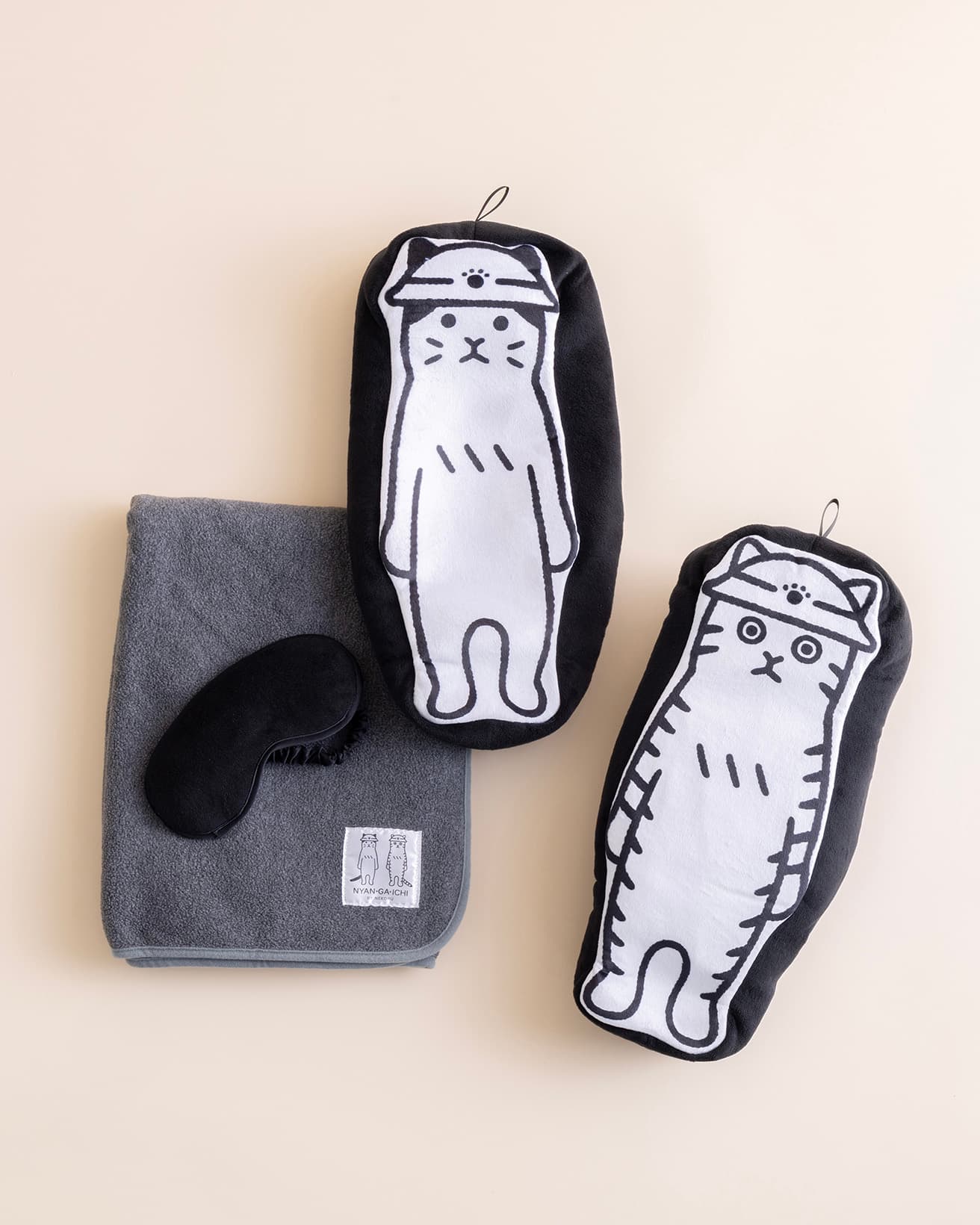 ぬいぐるみの中にフリースブランケットとアイマスクを内蔵。ふだんはお部屋でクッションやひざ掛けとして、いざというときには避難所に一緒に連れて行けるほっこりニャイテムでございます。心細く不安なときにもそっと寄り添い癒してくださります。《そばにいるよ ぬいぐるみブランケット》左／いつもくんver.、右／もしもくんver.各5,270円。