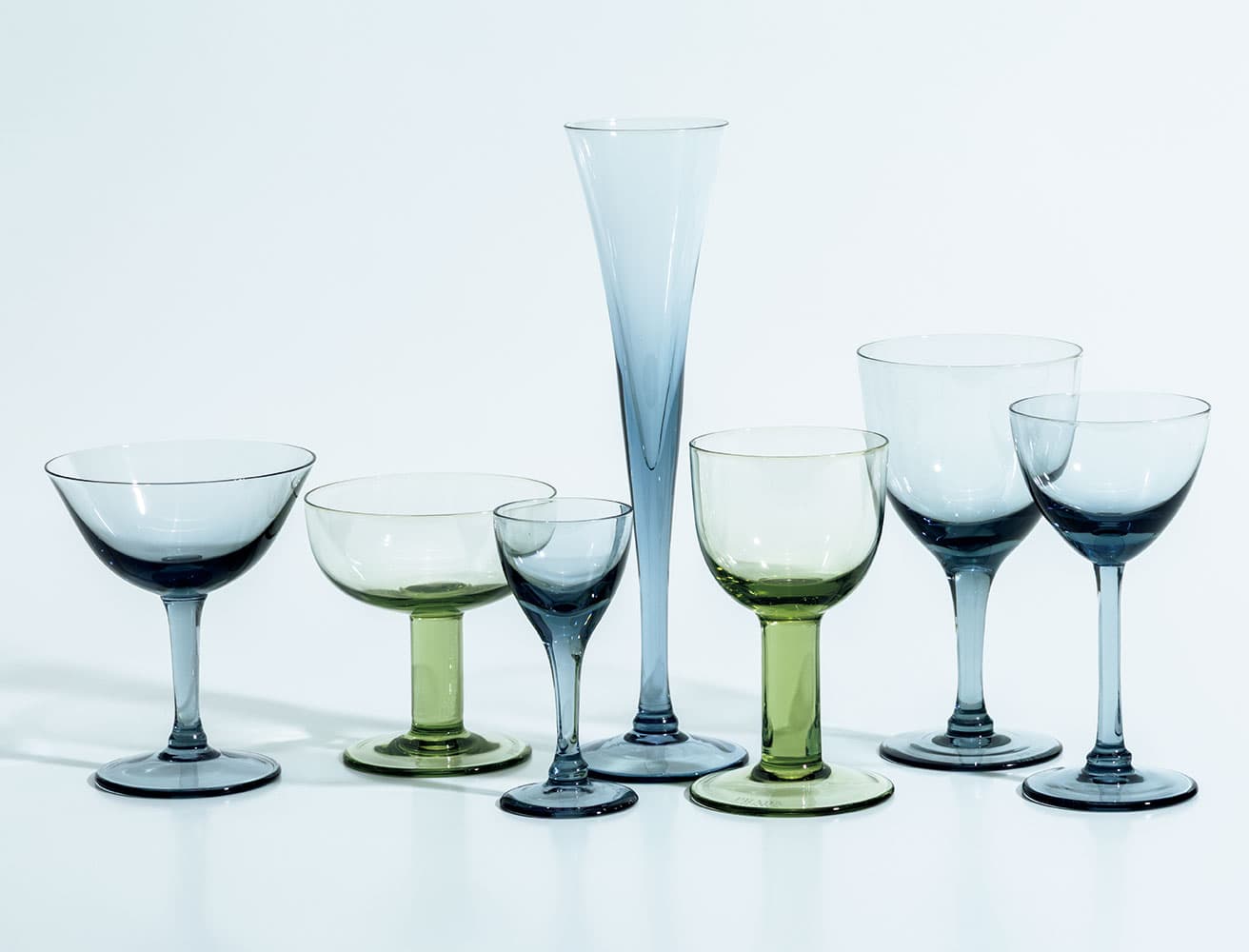 グラデーションが美しいボヘミアクリスタル。《New York》と《Plinth》ラインのグラスウェアセット。左からシャンパンクープグラス50,600円（以下すべて予定価格）、30,800円、リキュールグラス35,200円、フルートグラス46,200円、ホワイトワイングラス35,200円、ウォーターグラス50,600円、カクテルグラス46,200円※すべて2点セット価格。styling_Tomomi Nagayama