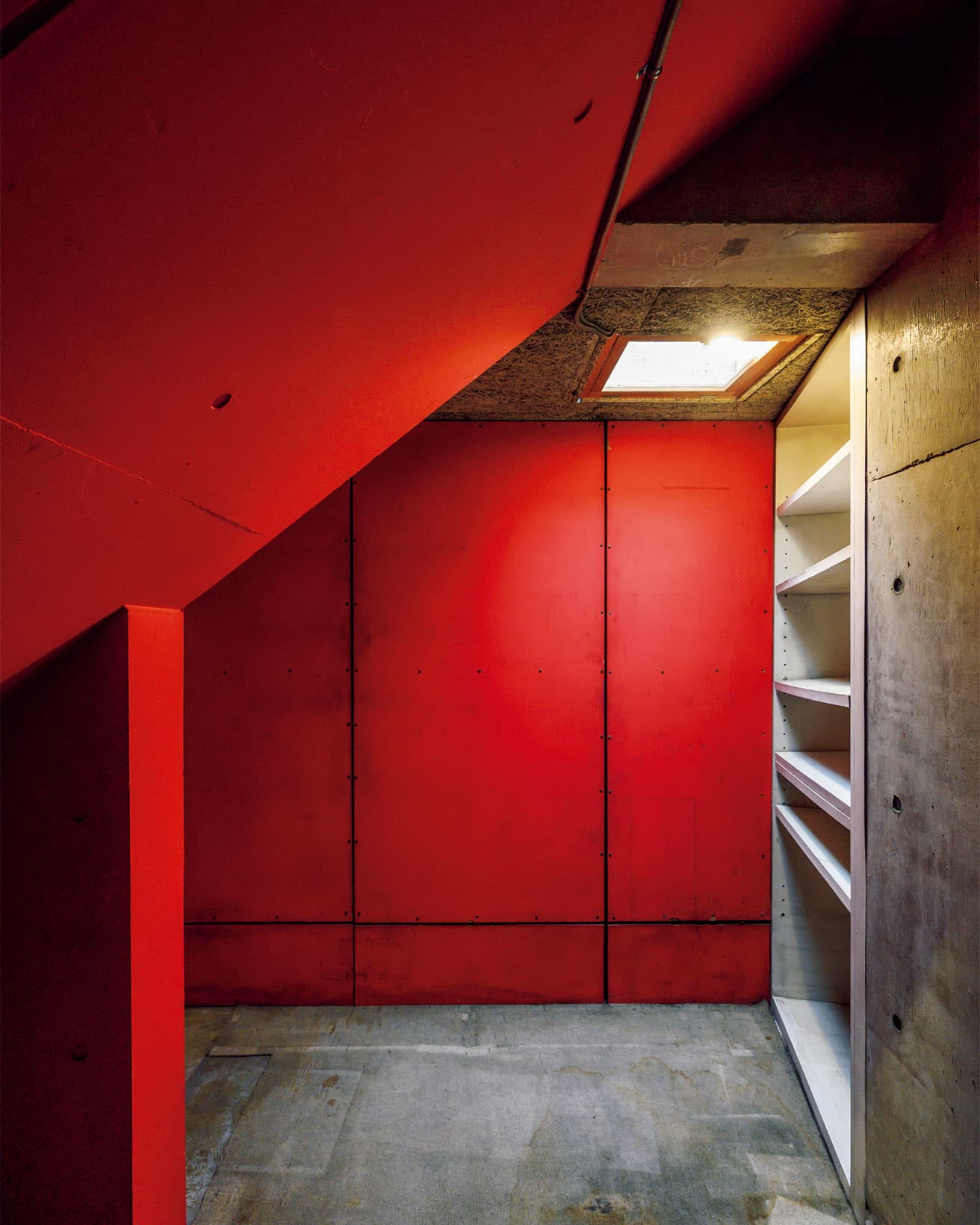 地下の書斎脇にある小部屋の壁は、竣工時からこのビビッドな赤。志郎康が集めた漫画コレクションが収められていた。