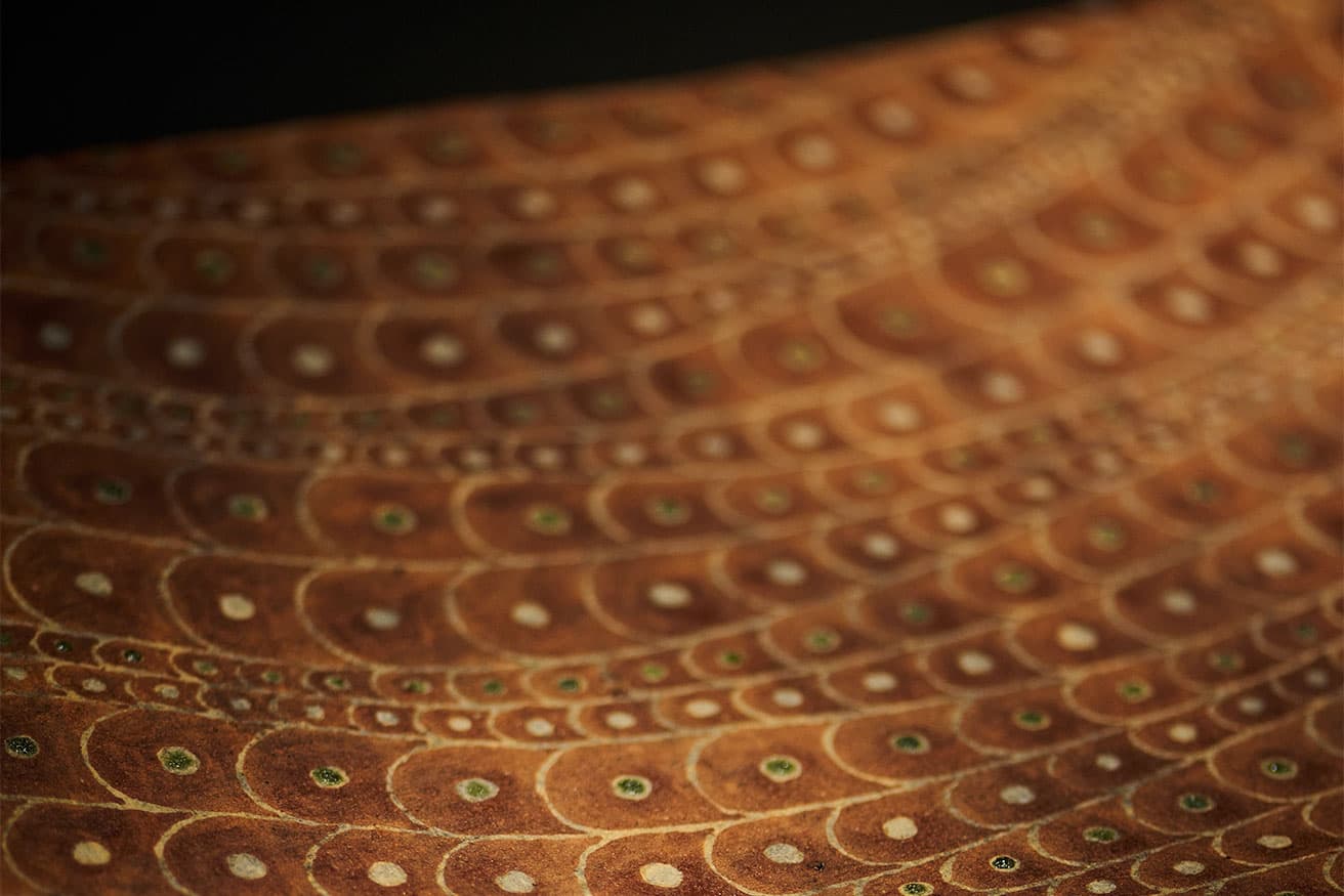 本焼成後に鱗の輪郭線を残すように彩釉して焼き、さらに点の部分に緑釉を塗って再び焼成する手の込んだ造り。