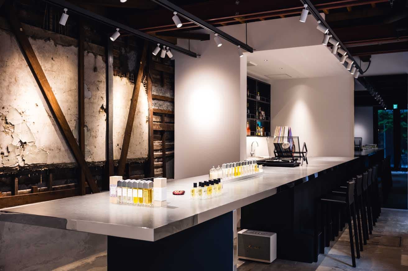昭和20年代の建物をリノベーションした〈ĖDIT(h)〉の店内。左手の壁は古い内装を解体した際に現れた土壁をそのまま残している。モダンな店内デザインとの対比が見事だ。
