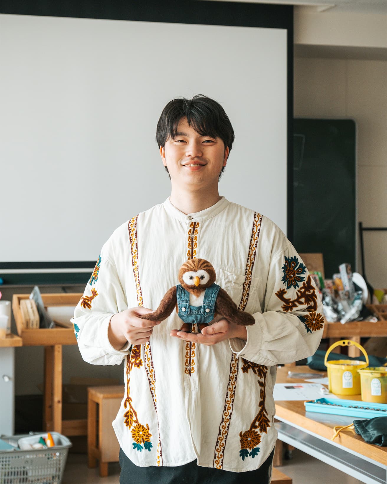 〈即興工作〉を手がける野呂祐人。函館短期大学で保育の造形表現を教えながら、動画での発信も行う。ともに写るのは、〈即興工作〉のマスコット的案内役のツクロウくん。
