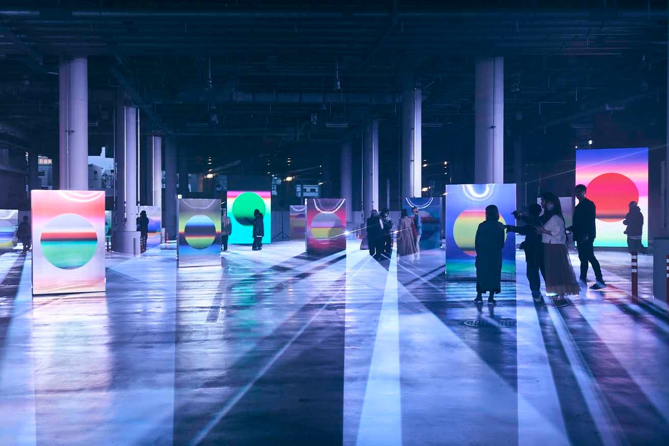 YOSHIROTTENの展開するアートプロジェクト「SUN」の展示の様子。コロナ禍に1日1枚、1年間手作業で着色された全365点のアートワークは、銀色の太陽が周囲の色彩を反射するイメージで構成されている。					
