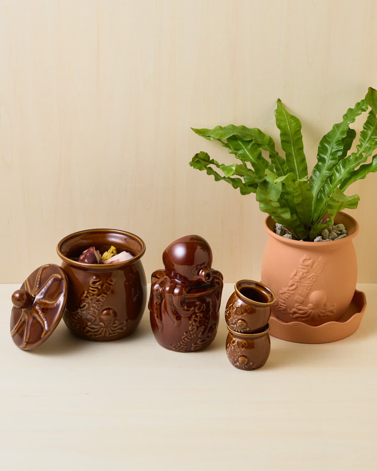 ユニークな見た目ながら、素材やつくりは本格的。インテリアのアクセントにもなりそうだ。（左から）《ひっぱりだこの蓋》680円、《ひっぱりだこ飯》1,480円、《ひっぱりだこの徳利》1,500円、《ひっぱりだこのお猪口》1個680円、《ひっぱりだこの植木鉢》1,500円。