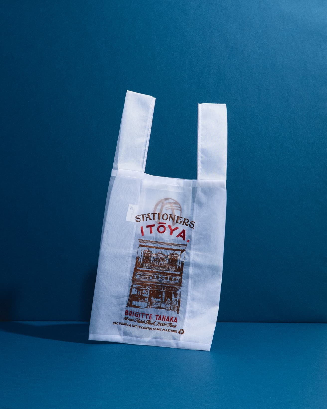 オーガンジーバッグには1904年創業の〈伊東屋〉の店構えを刺繍。右下にはよく見ると、お店でお留守番中の猫の姿も。