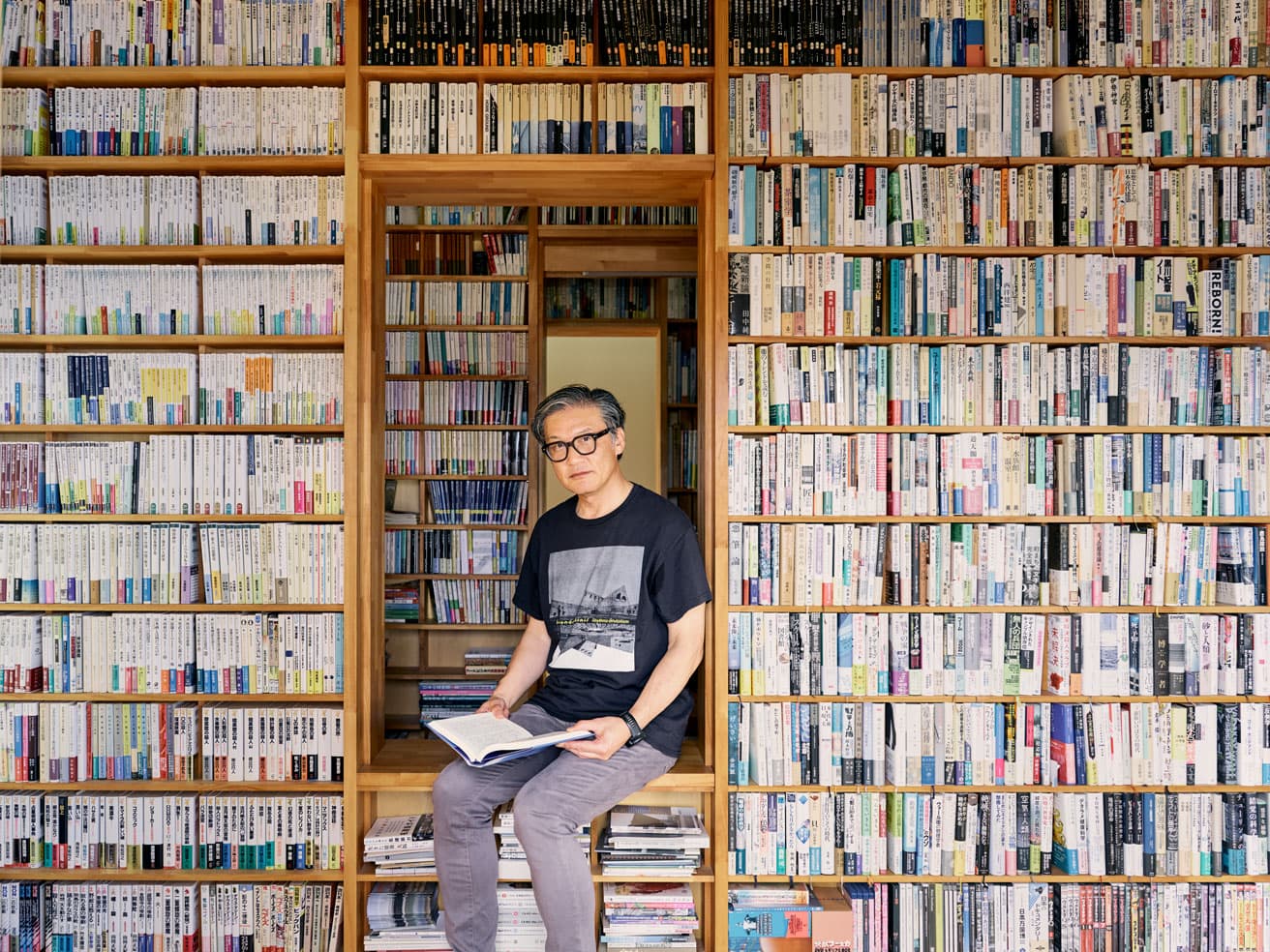リノベーションした実家の本棚に設けられたスペースで寛ぐ磯。この本棚の一角にCD棚がある。