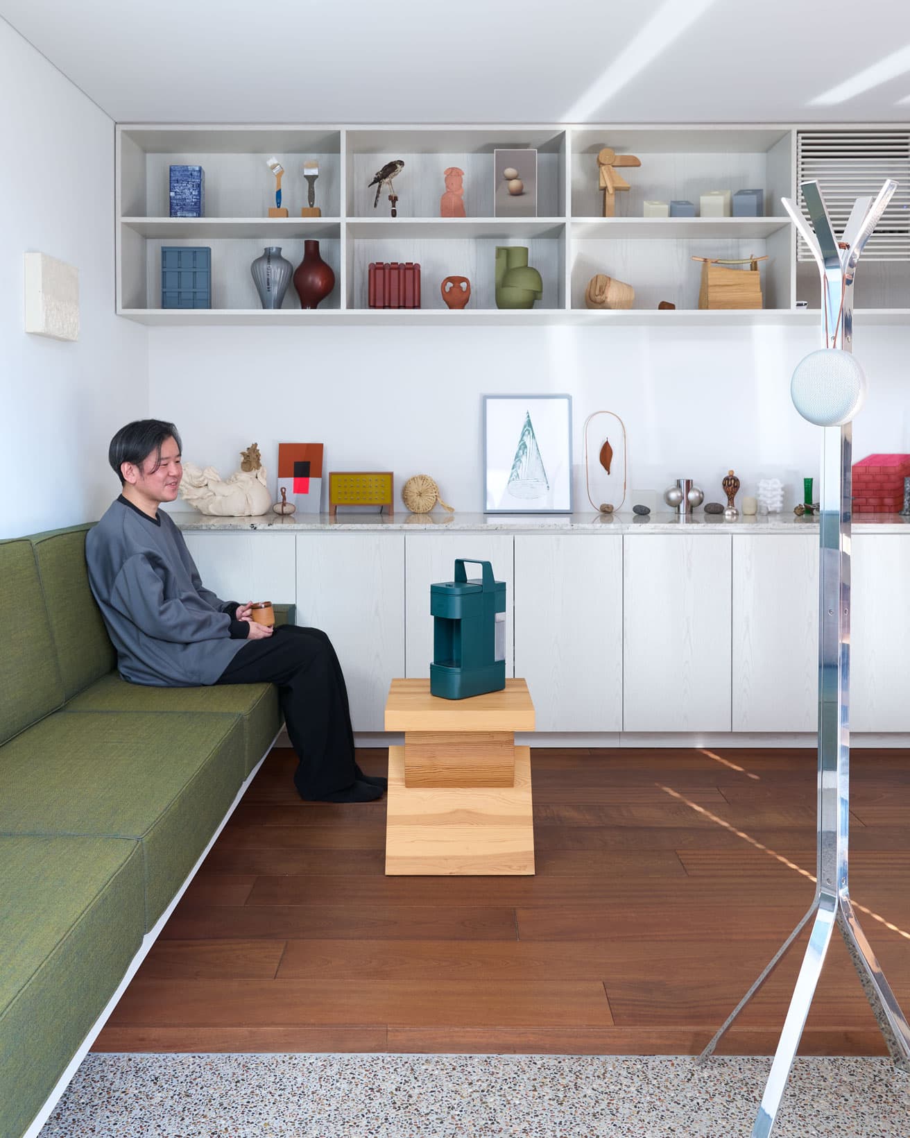 ギャラリーとリビングをつなぐ造作のソファや、キッチンへのびるカウンターも二俣公一によるデザイン。イ・カンホのサイドテーブルにボタニカルグリーンのマシンが映える。「いろんな角度から眺めたくなるデザインです」（山田さん）。