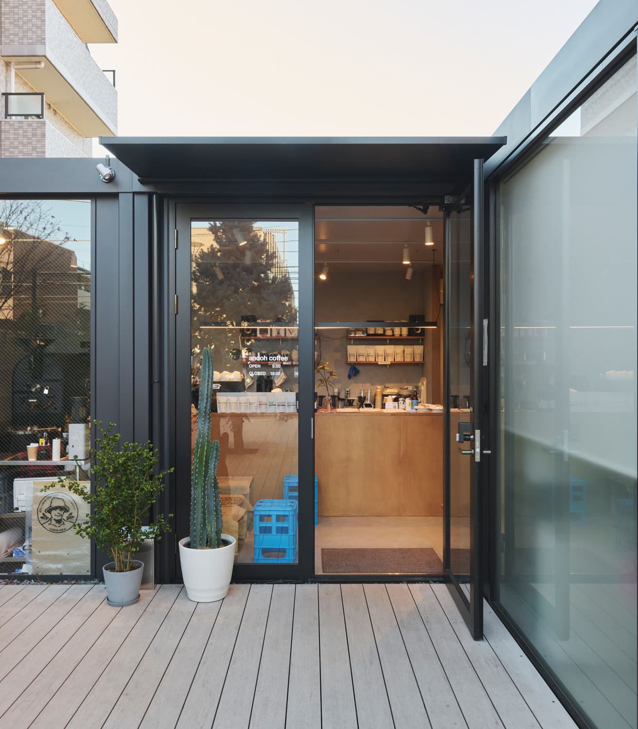 〈andoh coffee〉外観。ブラックの枠組みとガラスで構成されたシンプルで洗練されたデザインと、緩やかに配置された観葉植物。コーヒー好きはもちろん、初心者でも入店しやすい空間となっている。