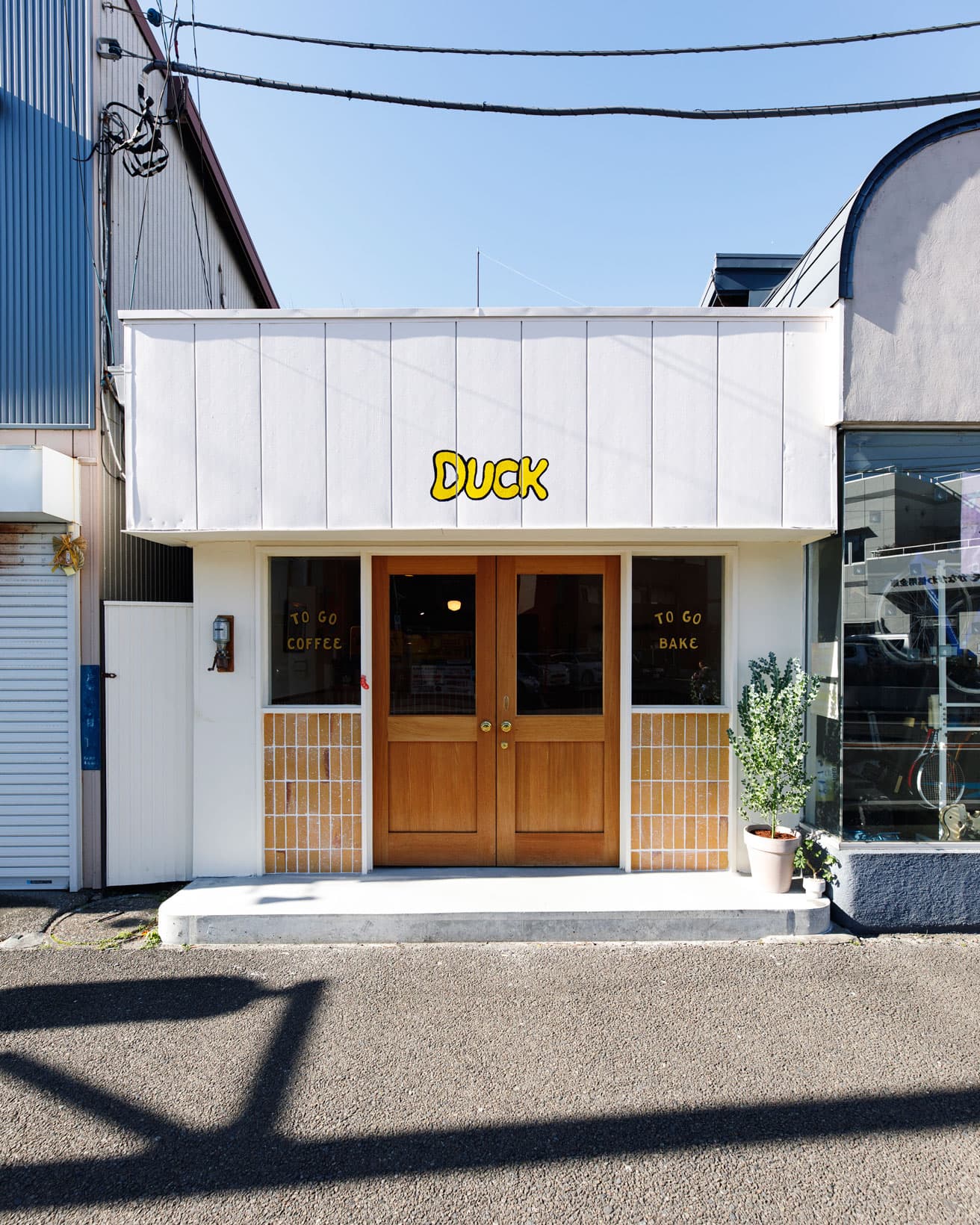 〈Coffee Parlor Duck〉外観。イエローのロゴマークが白を基調とした外装に映える。