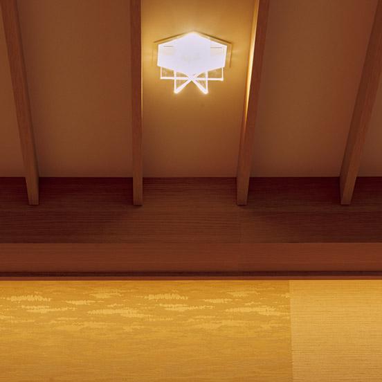 天井には亀甲紋形の間接照明を設置。壁には日本のテキスタイルを用い、壁と天井の切り返しの部分のディテールが浮かび上がるよう照明を工夫した。