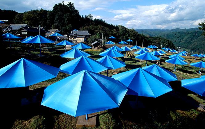 《アンブレラ》、日本での風景。青い傘が花のように広がる。　(c) Christo, 1991 photo_Wolfgang Volz