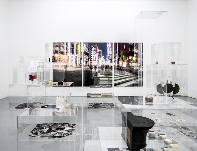 透明のケースの中に資生堂の歴代の製品や銀座の写真などを展示。正面の壁面にあるのは勝又公仁彦の写真作品。