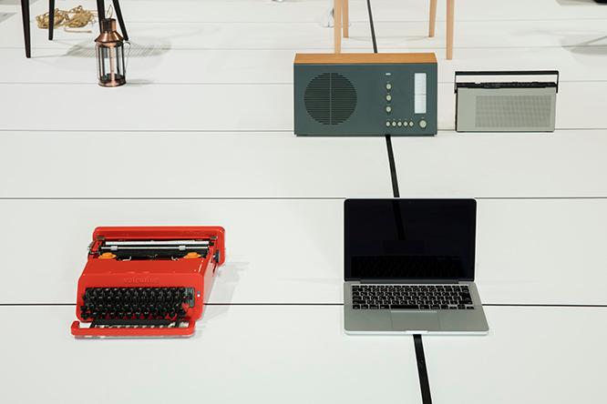 工芸とデザインの線上に置かれたアップルのノートパソコンを、深澤は「ひとりの職人が向き合った末の工芸品のよう」と解説する。左はエットレ・ソットサスによるタイプライター《ヴァレンタイン》、奥にはディーター・ラムスやバング&amp;オルフセンのラジオが見える。