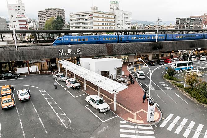 《油屋ホテル》（写真中央の白い建物）があるのはJR別府駅から徒歩10秒という抜群のロケーション。ちょうどJR九州の883系特急ソニックが入線してきたところ。