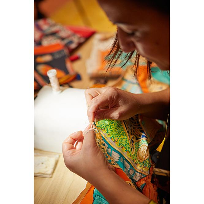 スカーフの縁かがりも手仕事だ。「ルロタージュ」と呼ばれる巻き縫いの方法で丁寧に仕上げられる。