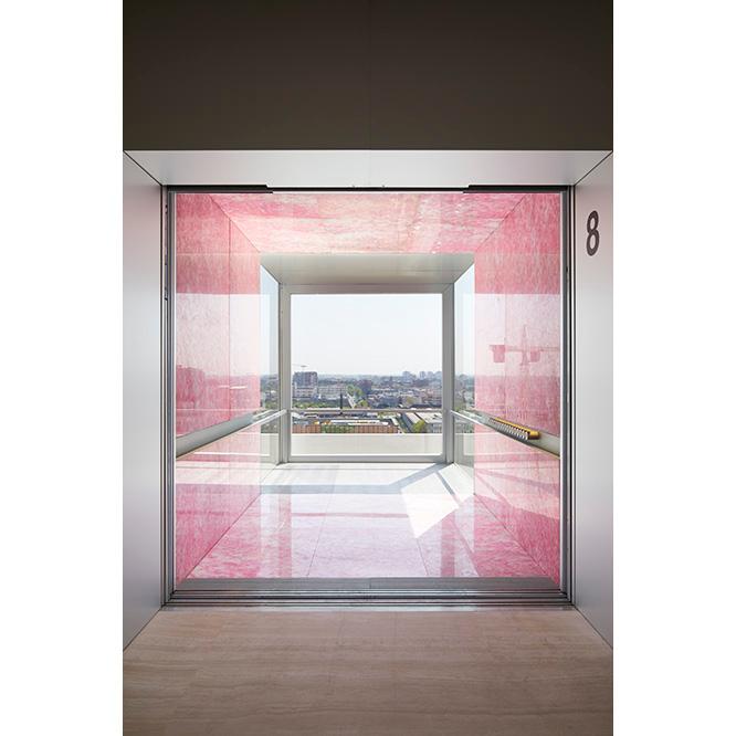 ピンクの大理石で覆われたエレベーター内部。ドアが開くと眩しいほどの光に大理石の色が照らされ、幻想的な感覚に陥る。
