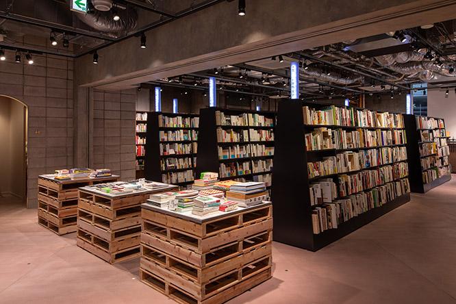 書棚は、出版社も判型もジャンルもバラバラの、感覚的な並び方。木製パレットの上に平積みされた書籍群は、“バウハウス関連”、“カレー関連”など、それぞれがテーマ別の塊になっています。