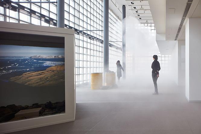 《グリーランド》展示風景。毎時15分・45分になると、ギャラリーの奥のほうから霧が滝のように流れてくる。