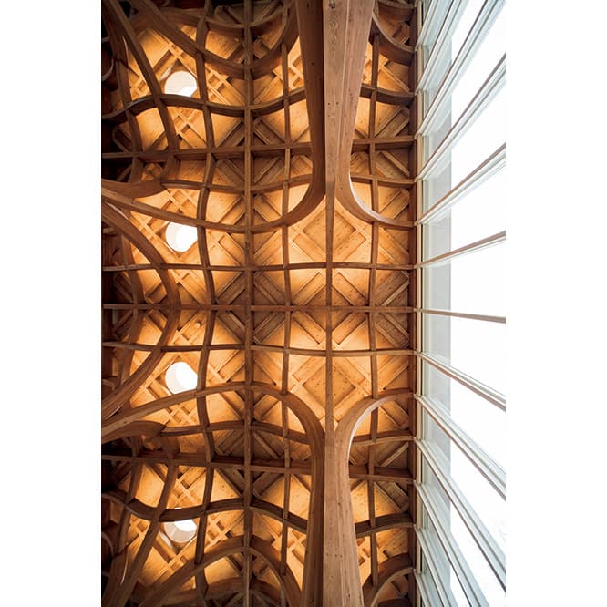 列車も見える2階の「旅の図書館」。椅子やテーブルも坂茂のデザイン。集成材の梁がリズミカルに続く。