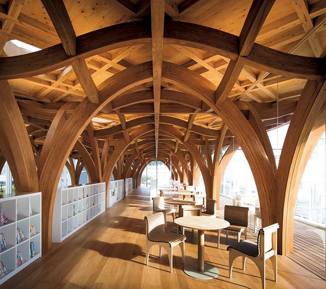 見上げると建物を支える木の柱や梁が幾何学的な模様を描く。