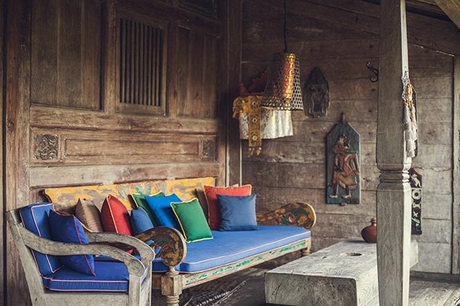 テラス屋根のついた玄関スペースにソファなどが置かれたヴィラでは、外を眺めながら飲み物を飲んだり食事をすることもできる。壁には古いインドネシアの手工芸品が飾られていた。