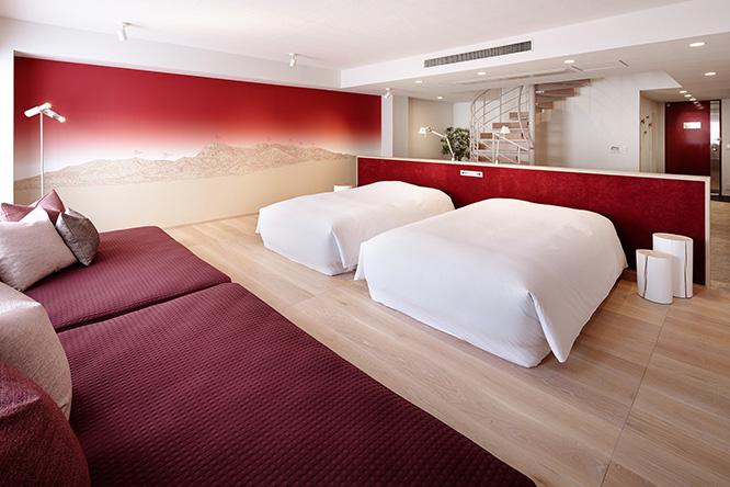 1階はベッドとデイベッドを備える、眠るための部屋。壁には八ヶ岳連峰が描かれている。