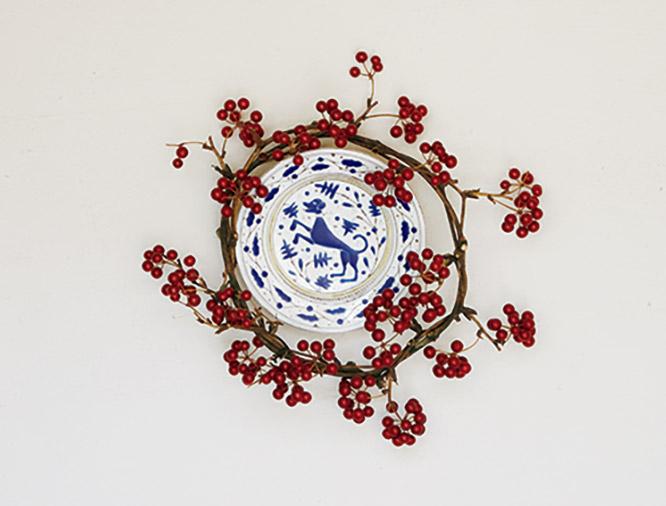 A display featuring a wreathed, painted dish. Depicted is a subject beloved by Mr. Takashima, the dog.