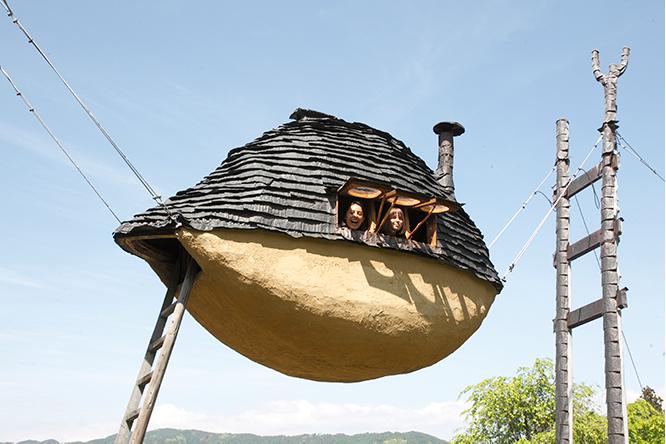 茶室《空飛ぶ泥舟》（2010年）。公募したワークショップ参加者と地元職人と藤森により制作された。宙に吊るされた茶室の足元にはネギ畑が広がる。
