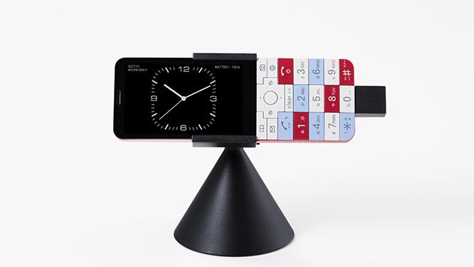 11月29日に発売される《INFOBAR xv》。充電中に卓上ホルダを使えば、置き時計のような雰囲気に。