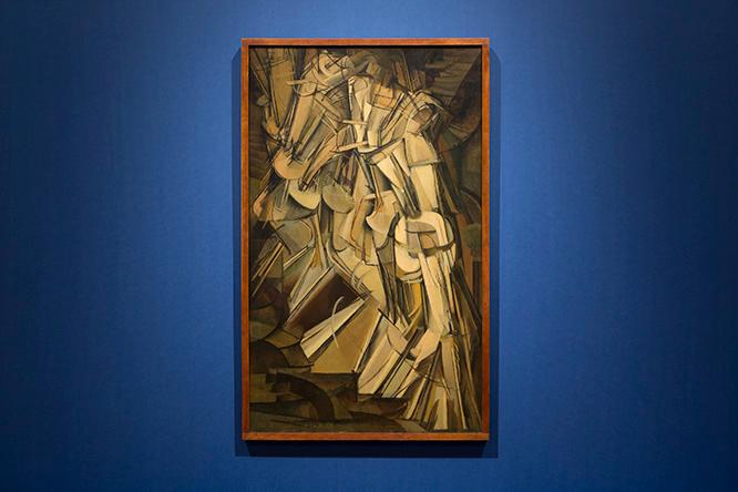 展示風景：《階段を降りる裸体　No.2》デュシャンはキュビストたちとの交流から、伝統的な絵画を超えた数学的な概念で、運動の抽象として移動中の身体を表現する独自のキュビスムを展開した。