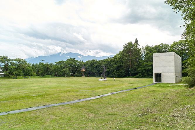 左に藤森照信設計の茶室〈徹〉、右に安藤忠雄の〈光の美術館〉。山並みを背景にした建築ミュージアムの趣も。