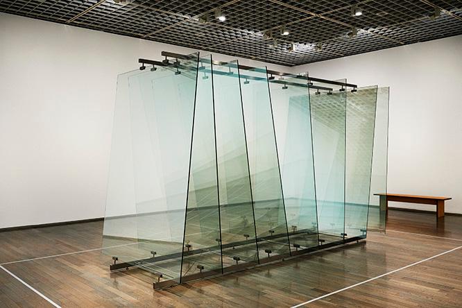 ゲルハルト・リヒター《8枚のガラス》。さまざまな角度に傾けられたガラスが、周囲のさまざまな像を映し出し、複雑に反射させる。 2012年 ガラス、スチール構造物 ワコウ・ワークス・オブ・アート