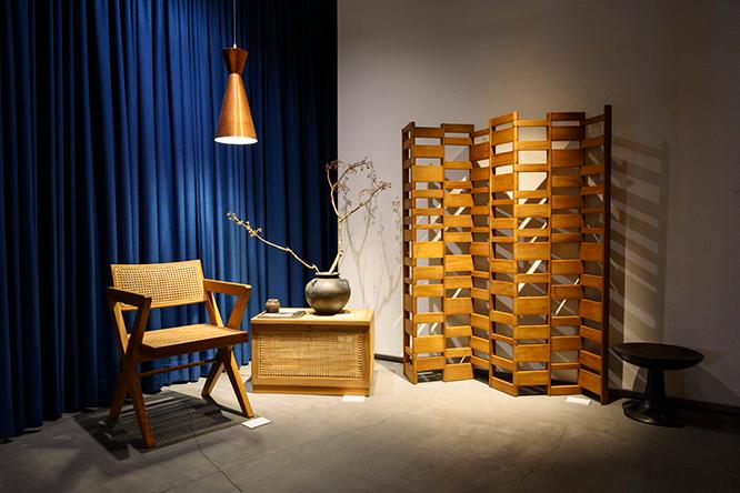 展示一角より脚部とアームレストが一体的に組み立てられる《X−leg Office Chair》（360,000円）とパンジャブ州議会議員のための集合住宅や病院で使用されたランドリーボックス《Linen Basket》（450,000円）。アムステルダムのデザインユニットX＋Lが製作した衝立や中西洋人の木製作品とコーディネート。