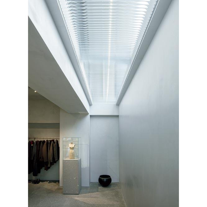 路面側を壁面で閉じたエントランスは天井からの光を取り込むことで柔らかな印象に。