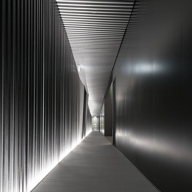 建物を貫く廊下は、壁と天井が格子によってできている。変化する光と音楽の演出によって、客を内部へと誘う。