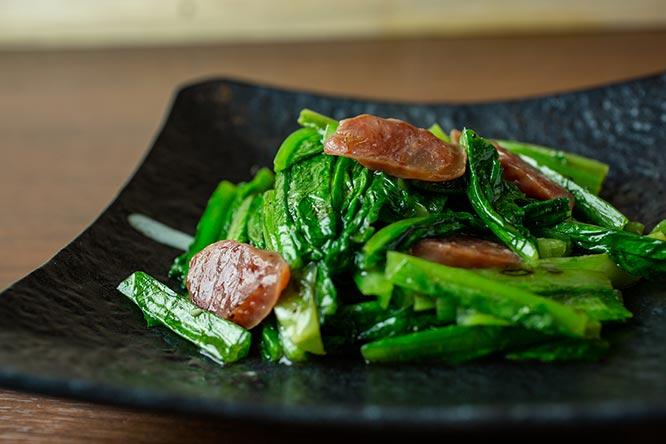 「A菜の腸詰炒め（中）」900円。ドラゴンでサッと炒めたレタス科の中国野菜、A菜は緑の色も鮮やか。