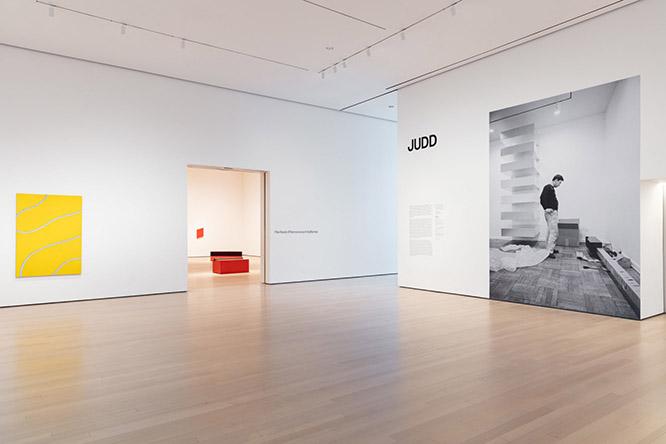 エントランス。若き日のジャッドが出迎える。© 2020 The Museum of Modern Art, New York. Photo: Jonathan Muzikar