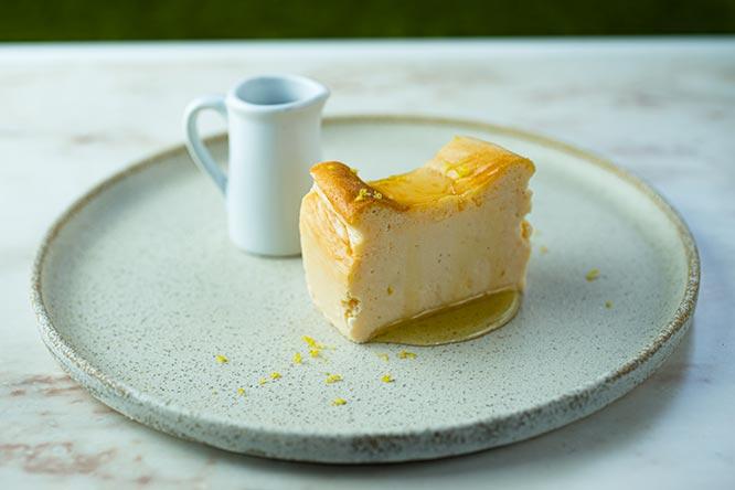 「国産レモンのしっとりベイクドチーズケーキ」1,000円。フランスの貴腐ワイン、ソーテルヌを詰めただけという贅沢なソースをかければ、気品あふれる風味に。