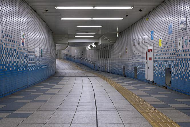 神戸市営地下鉄海岸線　駒ヶ林駅コンコース 　《白の拷問》。ゆるやかにカーブした地下道に、収監者の証言をもとに再現したグアンタナモ湾収容キャンプが出現する。