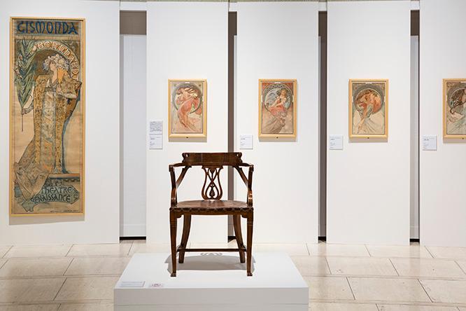 展示はアール・ヌーヴォーのエリアから始まる。中央はヤン・コチェラの肘掛椅子（国民劇場支配人室用）、背景はアルフォンス・ミュシャのポスター「ジスモンダ」など。植物などからインスピレーションを得た曲線が特徴だ。