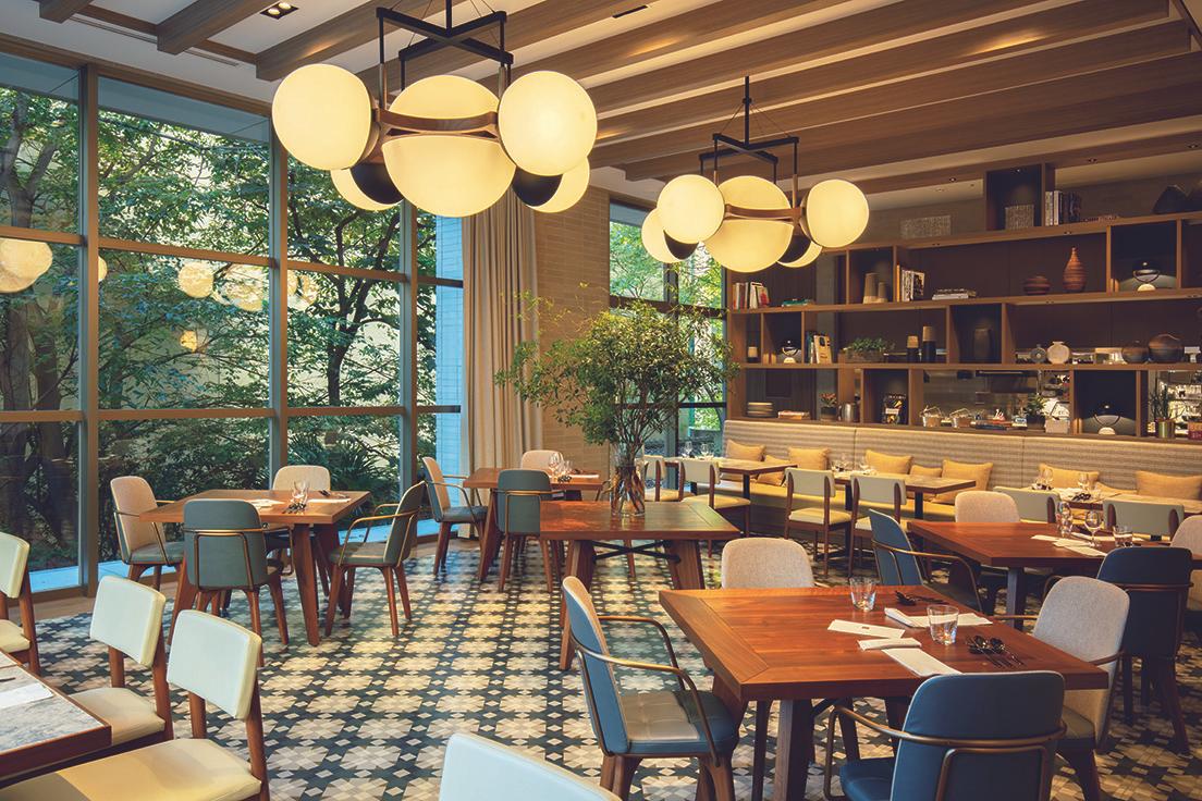 〈アップステアーズ〉のレストラン席は、ペールブルーと淡いマスタードを基調に、家具の木部をダークブラウンにして上質なムードを漂わせている。